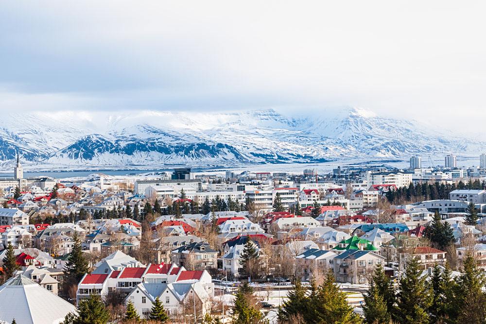 Toits colorés de Reykjavik sous la neige, montagnes enneigées en arrière-plan